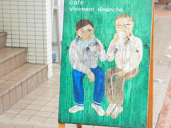 二人の紳士が描かれた緑の看板